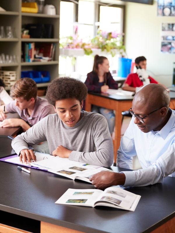Boy being helped by a teacher at school