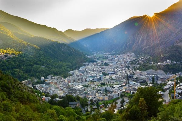 City in Andorra between forest covered mountains