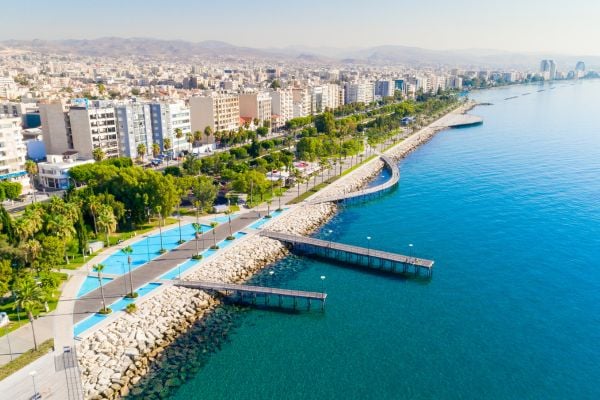 Promenade lined with trees and tall buildings beside the sea in Cyprus
