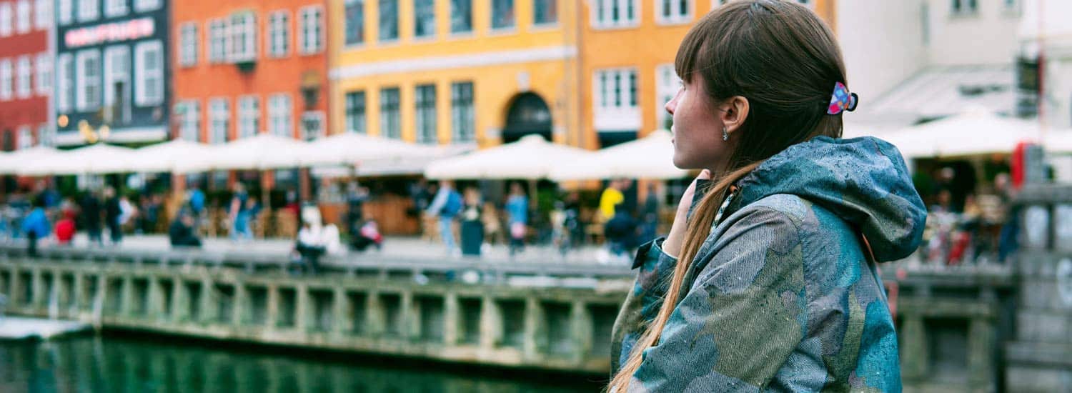 Woman standing by a river in Denmark